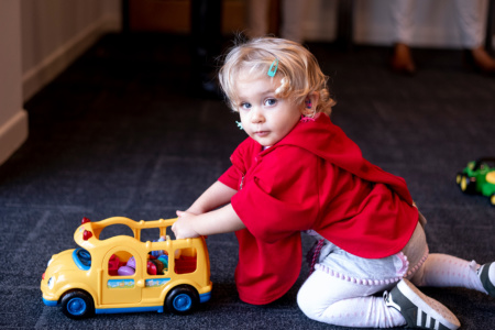 Child Playing With Toy Bus Flipped