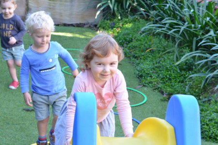 Three Children Playing On Slide